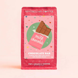 Chocolate Bar Joyground Coffee front packaging featuring a milk chocolate candy bag on a pink bag. 