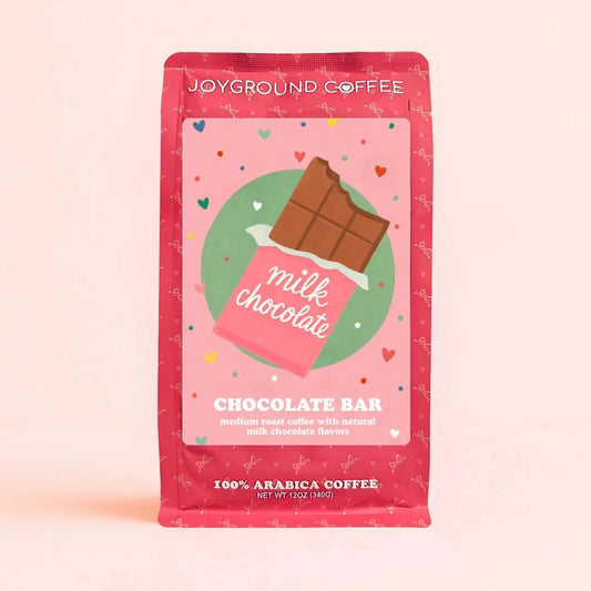 Chocolate Bar Joyground Coffee front packaging featuring a milk chocolate candy bag on a pink bag. 