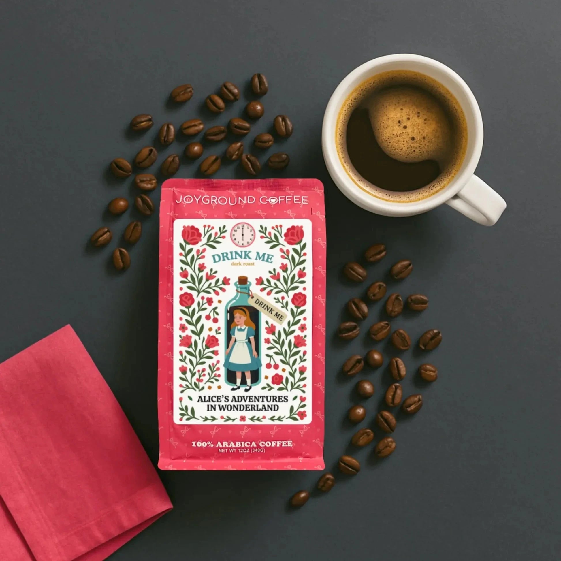 Alice in Wonderland Dark Roast coffee bag with coffee mug, coffee beans, and pink napkin