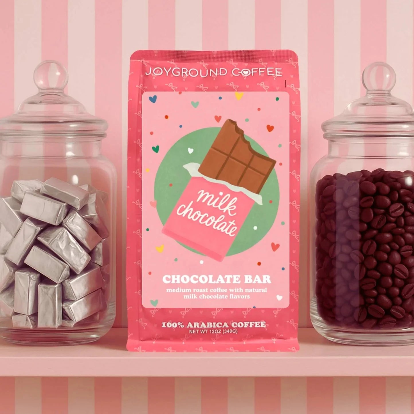 Bag of Chocolate Bar  flavored coffee from Joyground Coffee between jars of silver-wrapped mini chocolate candies and whole coffee beans.