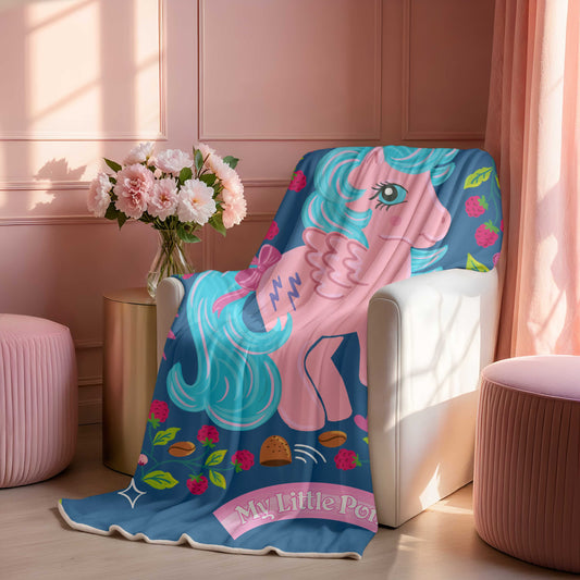 Beautiful sherpa fleece blanket with a My Little Pony Firefly design draped over a chair in a room with pink walls and decor.