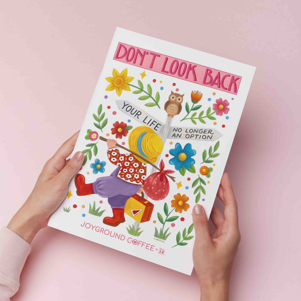 8x10 Mary Engelbreit x Joyground Coffee art print titled 'Don't Look Back' held by hands on a pink background