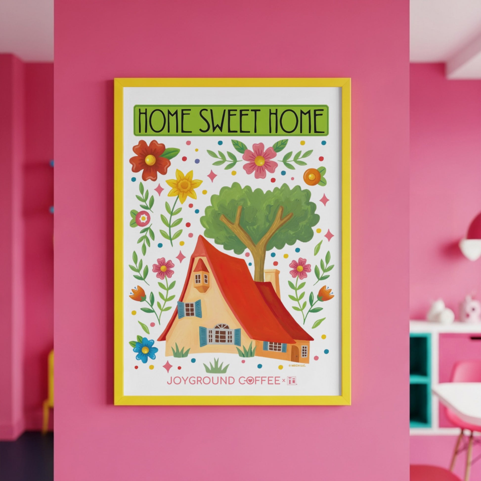 Framed Joyground Coffee x Mary Engelbreit artwork with Home Sweet Home text and house illustration on a pink wall.