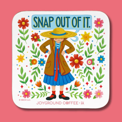 Coaster with illustration of a Mary Engelbreit character wearing a hat and coat, surrounded by flowers and text 'Snap Out of It.' on a pink background.