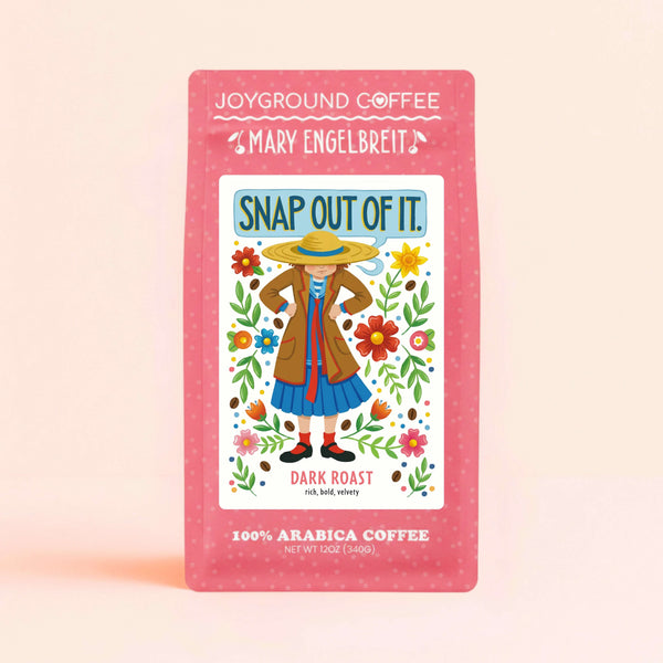 Mary Engelbreit x Joyground Coffee Snap Out Of It Dark Roast coffee bag with illustration of a stern woman wearing a straw hat with her hands on her hips surrounded by florals.