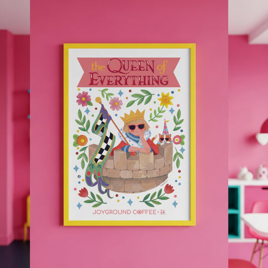 Framed artwork titled 'The Queen of Everything' by Mary Engelbreit and Joyground Coffee on a pink wall.