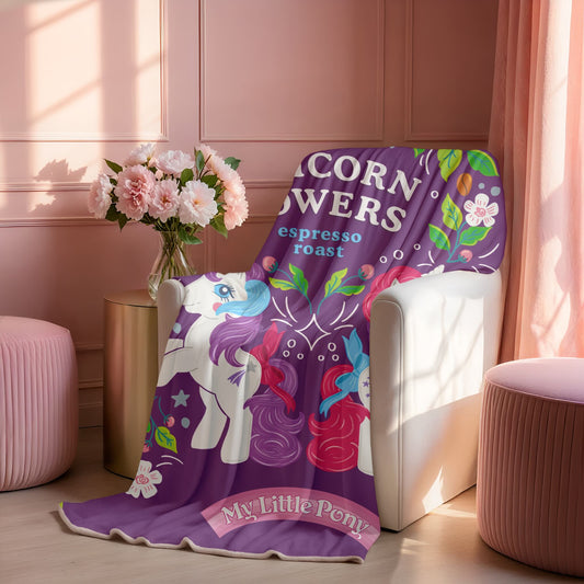 Purple 'My Little Pony' blanket draped over a chair in a room with pink walls and flowers.